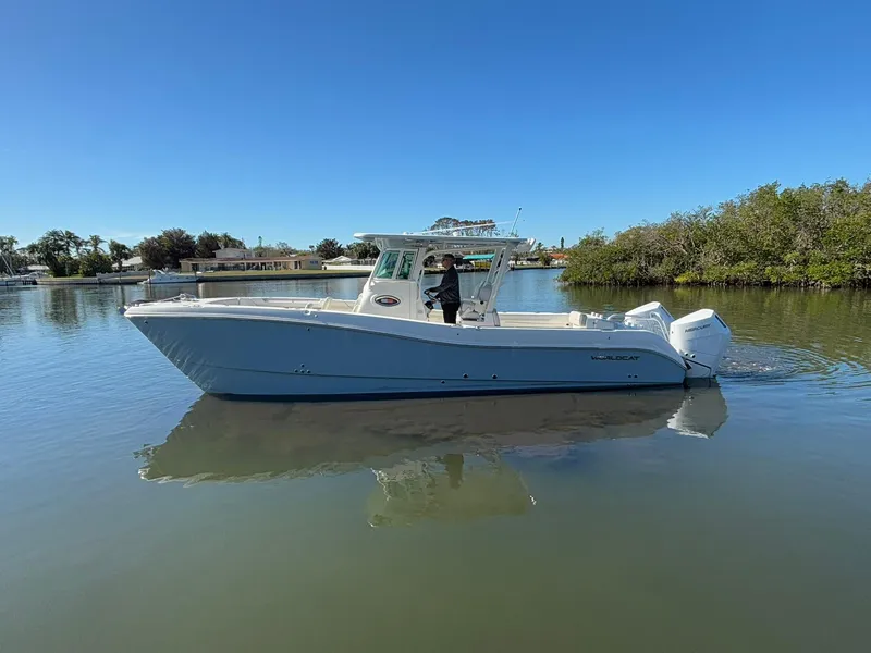 Slide: The Image of 2025 World Cat 325 CC boat on calm water, clear sky background. - 4