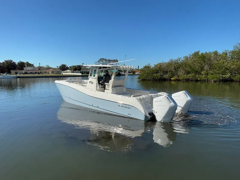 Slide: The Image of 2025 World Cat 325 CC boat cruising on calm water under clear blue sky. - 5