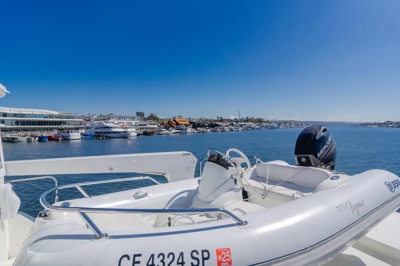 Slide: The Image of 2008 Ocean Alexander Pilothouse yacht with tender on deck, overlooking marina and blue waters. - 15