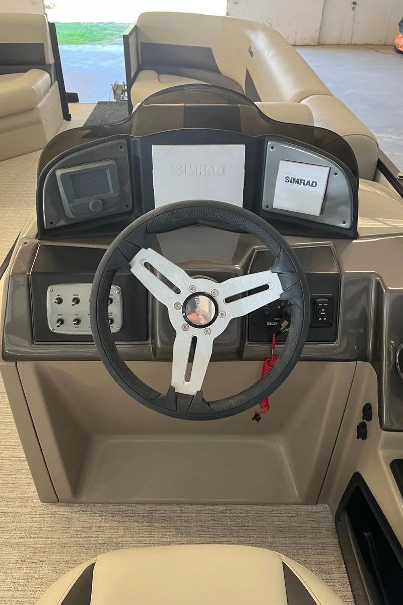 Slide: The Image of 2023 Xcursion 243 PFX boat dashboard with steering wheel and Simrad electronics. - 10