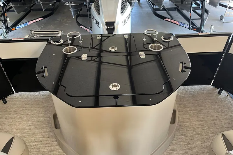 Slide: The Image of 2023 Xcursion 243 PFX boat interior with sleek black table and cup holders. - 11