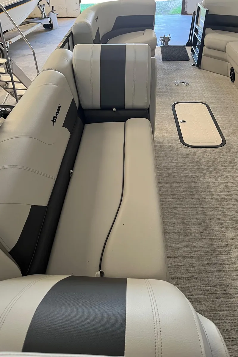 Slide: The Image of 2023 Xcursion 243 PFX boat interior with gray seating and carpeted floor. - 15