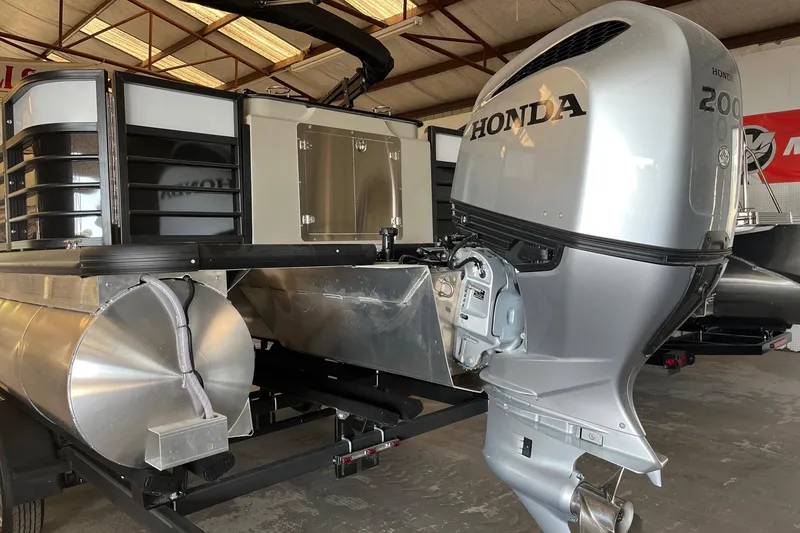 Slide: The Image of 2023 Xcursion 243 PFX pontoon boat with Honda 200 outboard motor in a warehouse. - 17