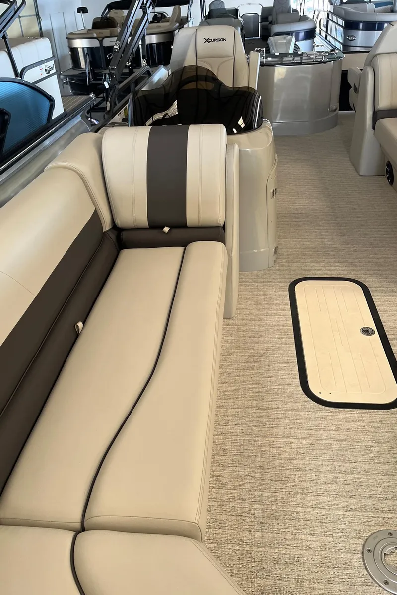 Slide: The Image of 2023 Xcursion 243 PFX boat interior with beige seating and carpeted floor. - 8