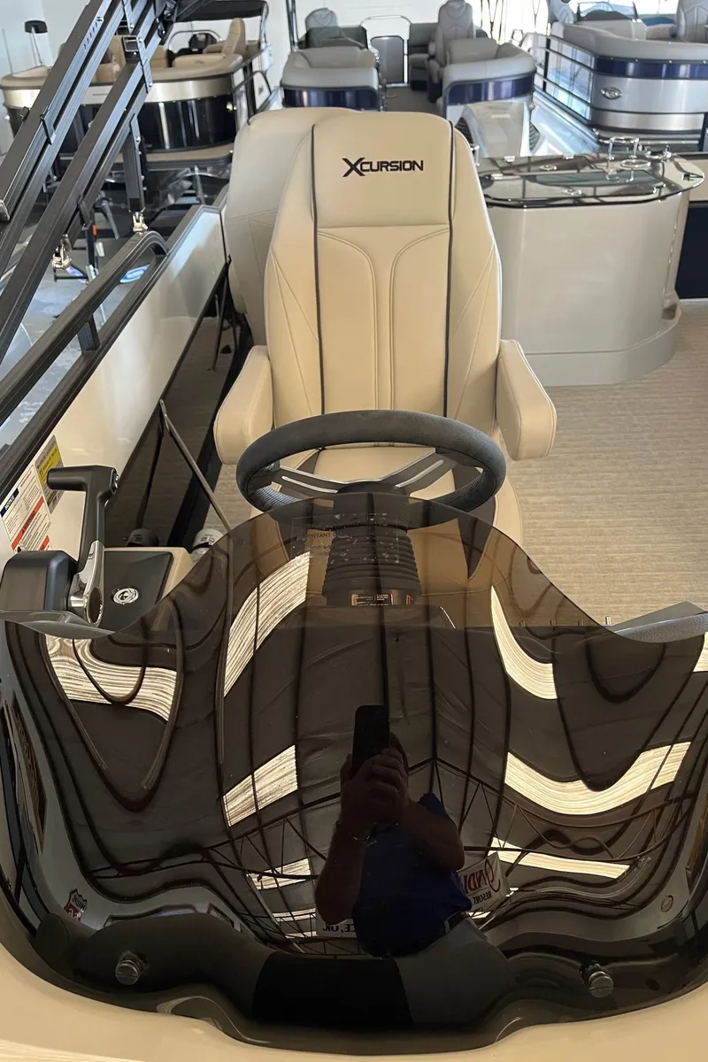 Slide: The Image of 2023 Xcursion 243 PFX boat interior with steering wheel and seating. - 9