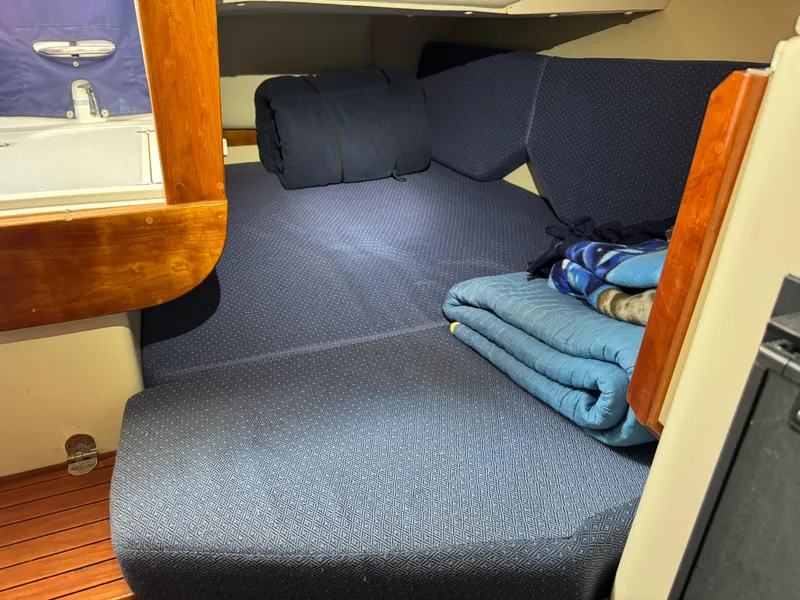 Slide: The Image of 2005 Albin 28 Tournament Express cabin interior with blue cushions and folded blankets. - 24