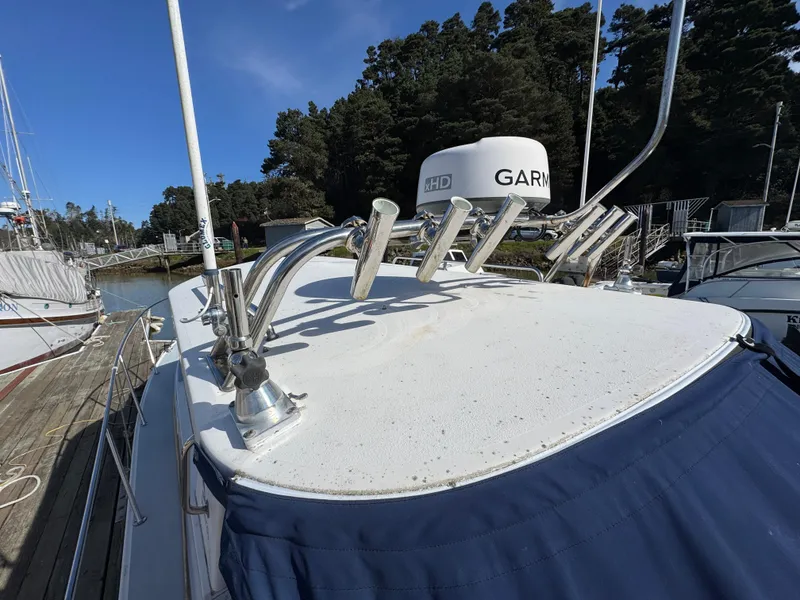 Slide: The Image of 2005 Albin 28 Tournament Express boat with radar and rod holders, docked near trees. - 28