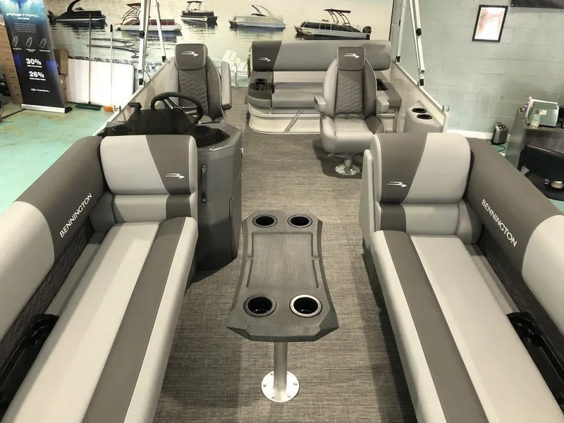 Slide: The Image of 2025 Bennington S Swingback 22 SSB pontoon boat interior with gray seating and central table. - 3