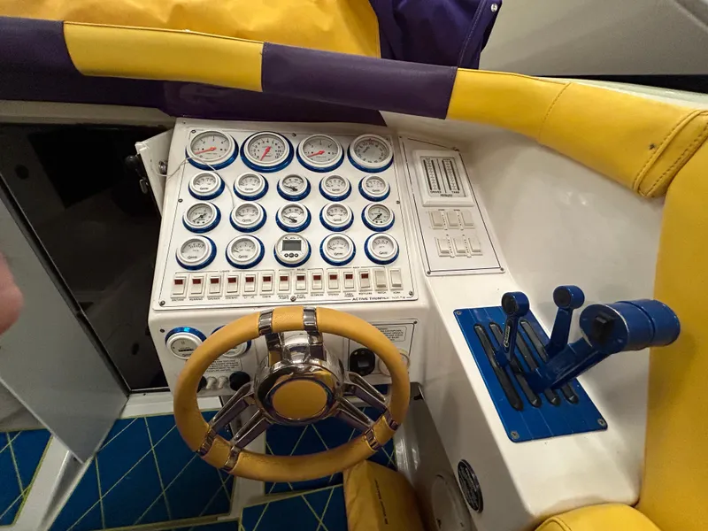 Slide: The Image of Control panel of a 2000 Active Thunder 370 Excess boat with gauges and steering wheel. - 12