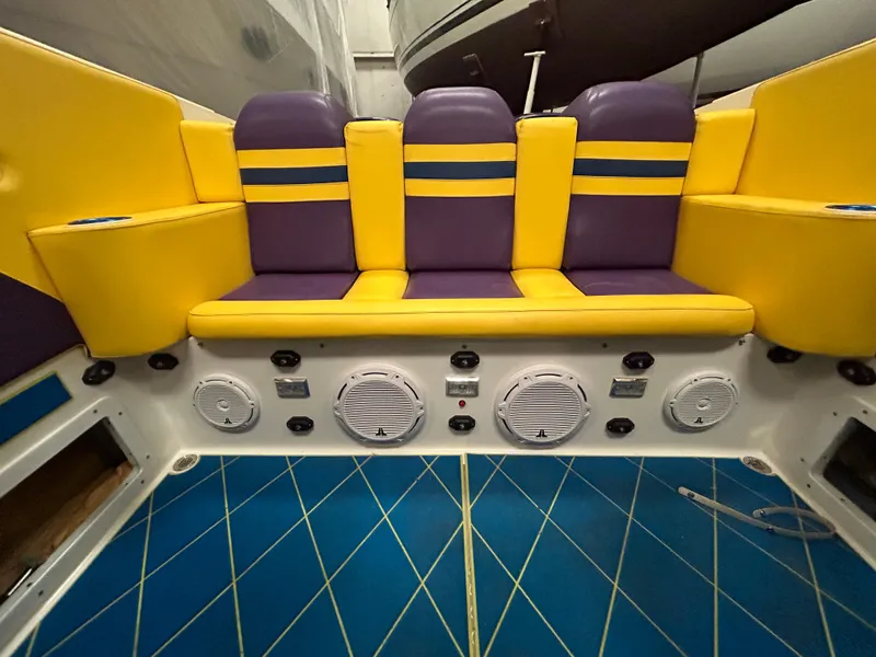 Slide: The Image of Interior seating of a 2000 Active Thunder 370 Excess boat, featuring vibrant yellow and purple upholstery. - 8