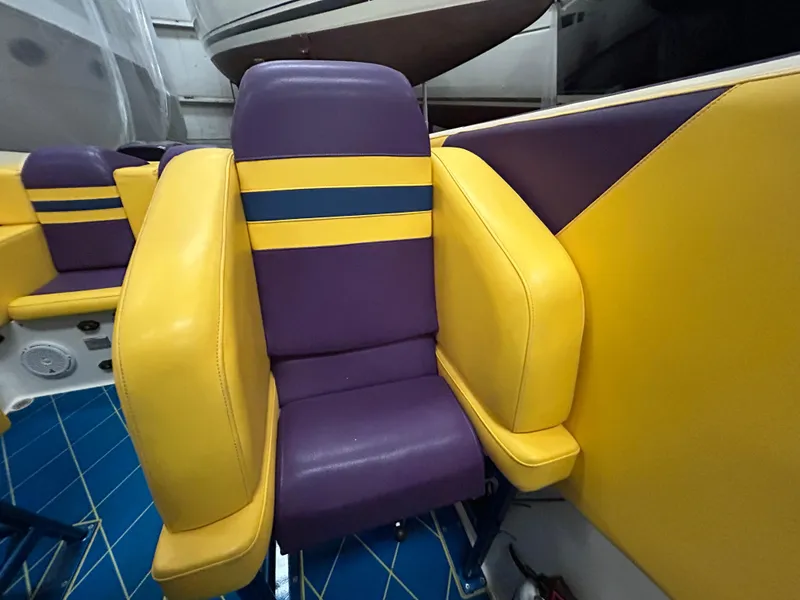 Slide: The Image of Colorful seating on a 2000 Active Thunder 370 Excess boat, featuring purple and yellow upholstery. - 9
