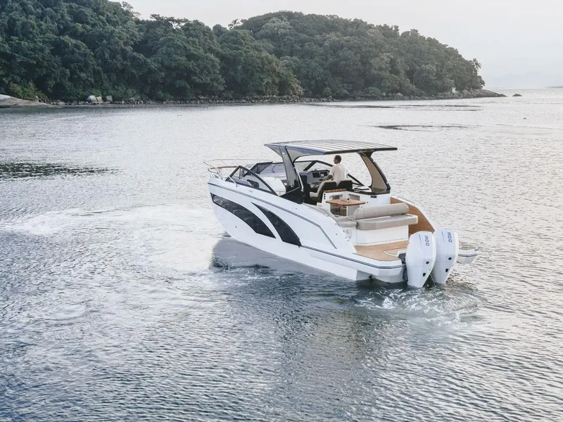 Slide: The Image of 2024 Hanover 347 boat cruising on serene water near lush green island. - 2