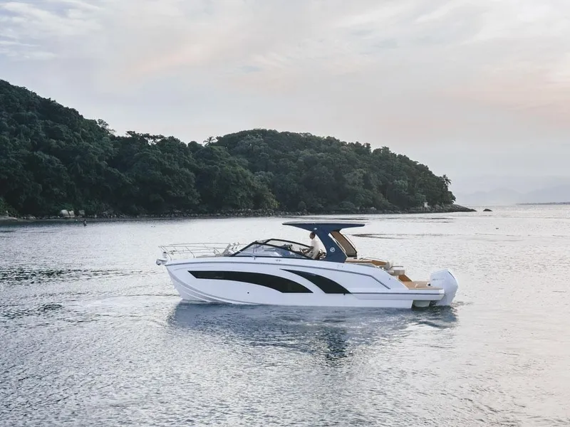 Slide: The Image of 2024 Hanover 347 boat cruising on serene waters near a lush, green island. - 3