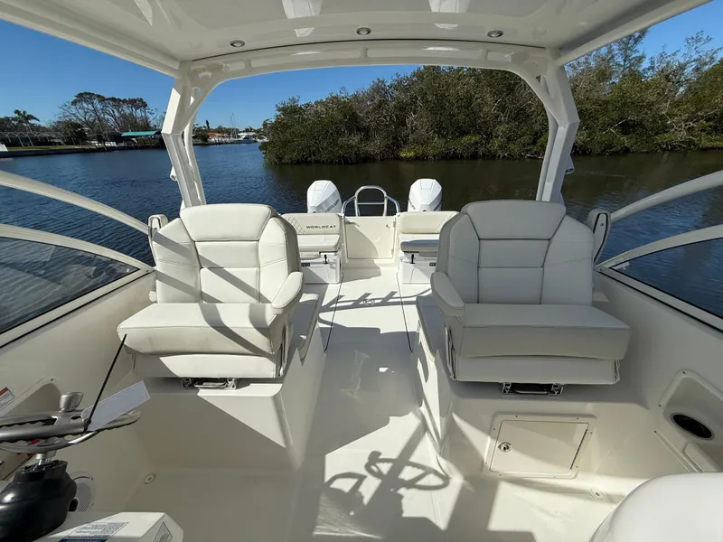 Slide: The Image of 2025 World Cat 296 DC boat interior with plush seating and scenic water view. - 12