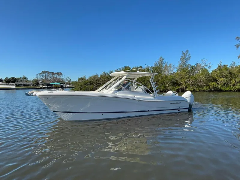 Slide: The Image of 2025 World Cat 296 DC boat on calm water, clear blue sky background. - 4