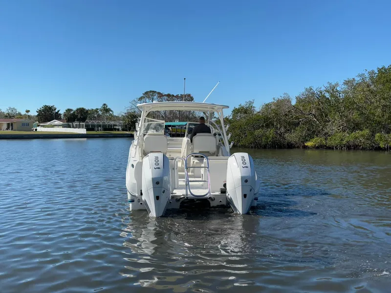 Slide: The Image of 2025 World Cat 296 DC boat on calm water, rear view with dual engines. - 6