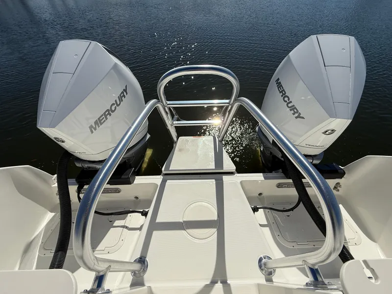 Slide: The Image of 2025 World Cat 296 DC boat with dual Mercury outboard engines on a sunny day. - 7