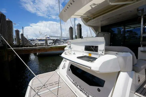 Slide: The Image of 2021 Beneteau Monte Carlo 52 yacht docked at marina, featuring outdoor grill. - 10
