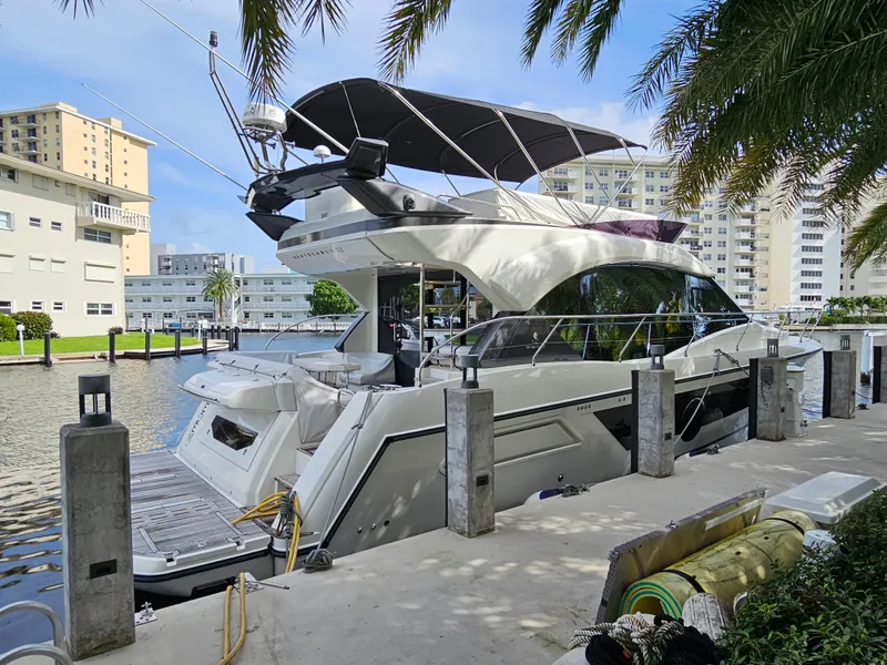 Slide: The Image of 2021 Beneteau Monte Carlo 52 yacht docked in a marina, surrounded by palm trees. - 3