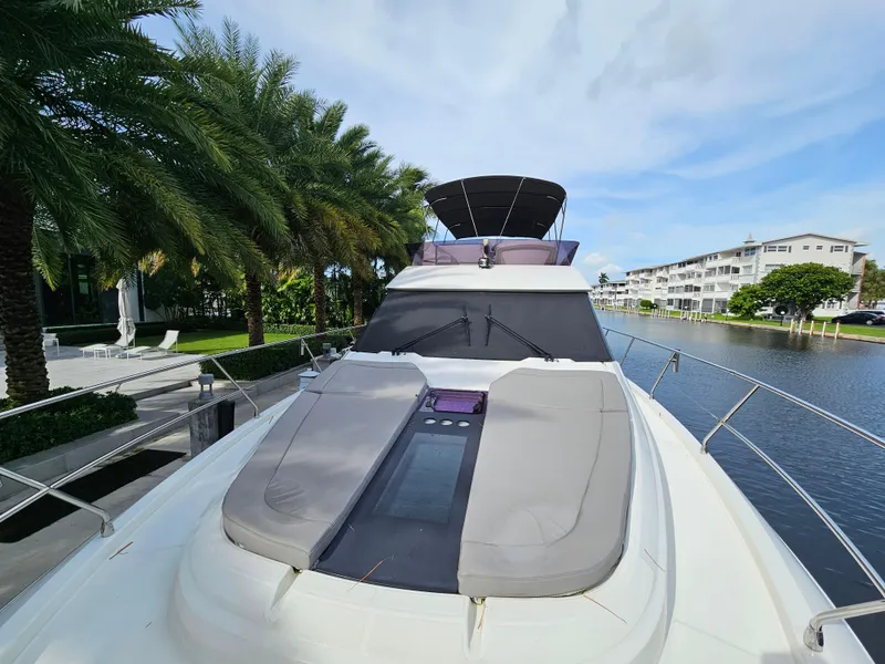 Slide: The Image of 2021 Beneteau Monte Carlo 52 yacht docked by a canal, featuring spacious deck seating. - 5