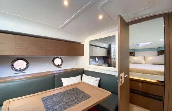 Slide: The Image of Interior of 2019 Beneteau Gran Turismo 40 yacht, featuring a cozy dining area and bedroom. - 29