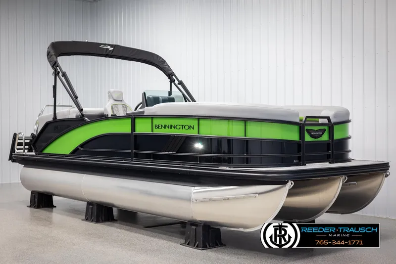 Slide: The Image of 2025 Bennington MFBSE pontoon boat with green and black design in showroom. - 2