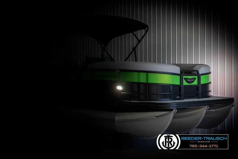 Slide: The Image of 2025 Bennington MFBSE pontoon boat with green accents, partially illuminated in a dimly lit setting. - 4