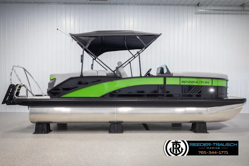 Slide: The Image of 2025 Bennington MFBSE pontoon boat with green accents in a showroom. - 5