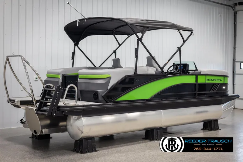Slide: The Image of 2025 Bennington MFBSE pontoon boat with green accents in a showroom. - 6
