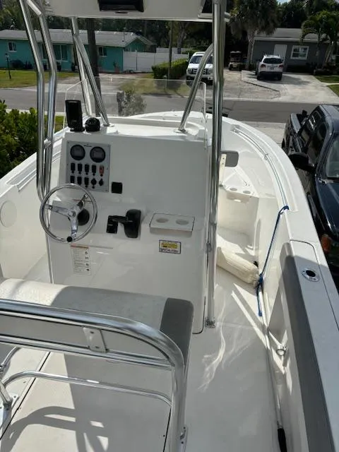 Slide: The Image of 2016 Release 208 RX boat with console and seating, parked in a residential area. - 10