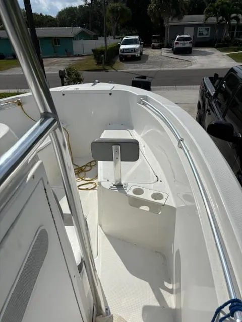 Slide: The Image of 2016 Release 208 RX boat interior with seating and rod holders, parked in a residential area. - 13