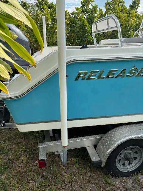 Slide: The Image of 2016 Release 208 RX boat on trailer, blue and white design, parked outdoors. - 8