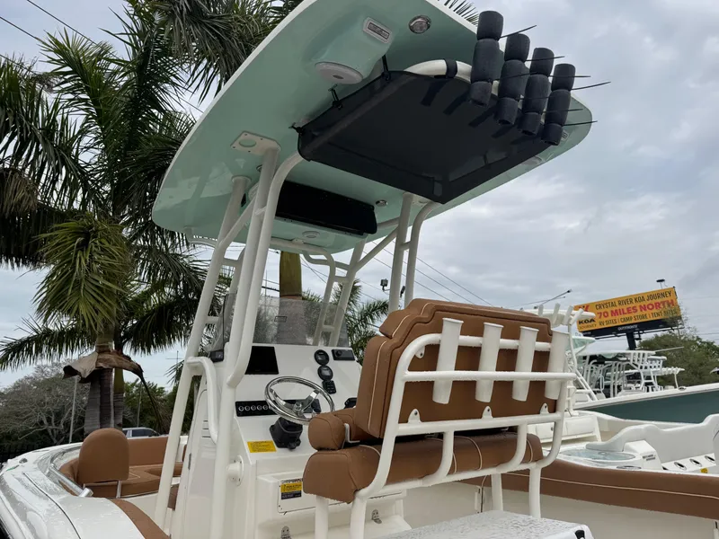 Slide: The Image of 2025 Key West 219 FS boat with seating and rod holders, under cloudy sky. - 10