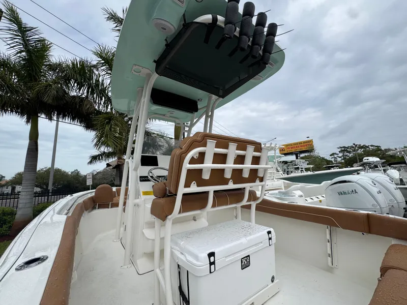 Slide: The Image of 2025 Key West 219 FS boat with seating and storage, docked under cloudy skies. - 12