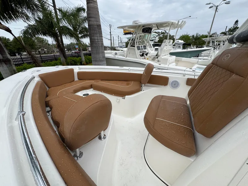 Slide: The Image of 2025 Key West 219 FS boat with tan seating, docked near palm trees. - 17