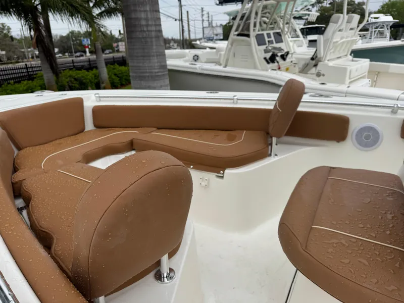 Slide: The Image of 2025 Key West 219 FS boat with brown seating, wet from rain, in a marina setting. - 18