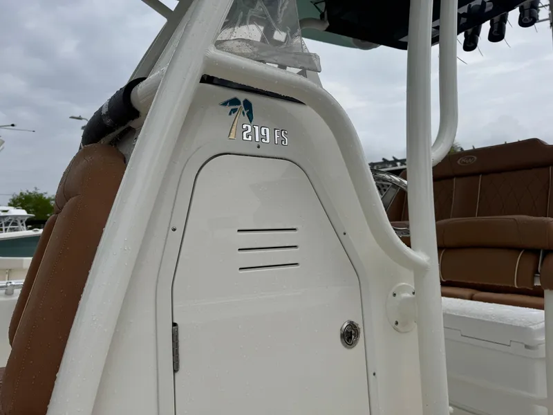 Slide: The Image of 2025 Key West 219 FS boat console with brown seating and white structure. - 19