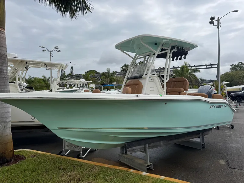 Slide: The Image of 2025 Key West 219 FS boat displayed outdoors on a stand. - 2