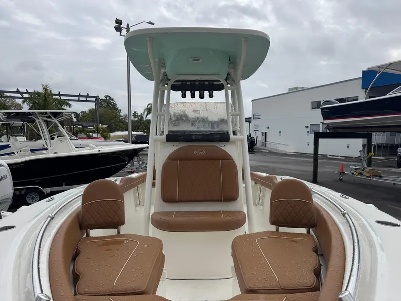 Slide: The Image of 2025 Key West 219 FS boat with tan seating, docked outdoors. - 21
