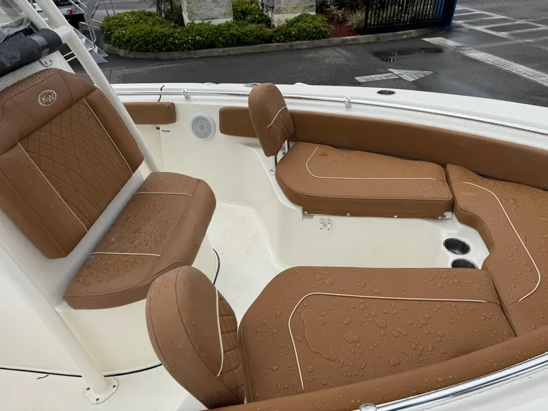 Slide: The Image of 2025 Key West 219 FS boat interior with brown cushioned seating, wet from rain. - 23
