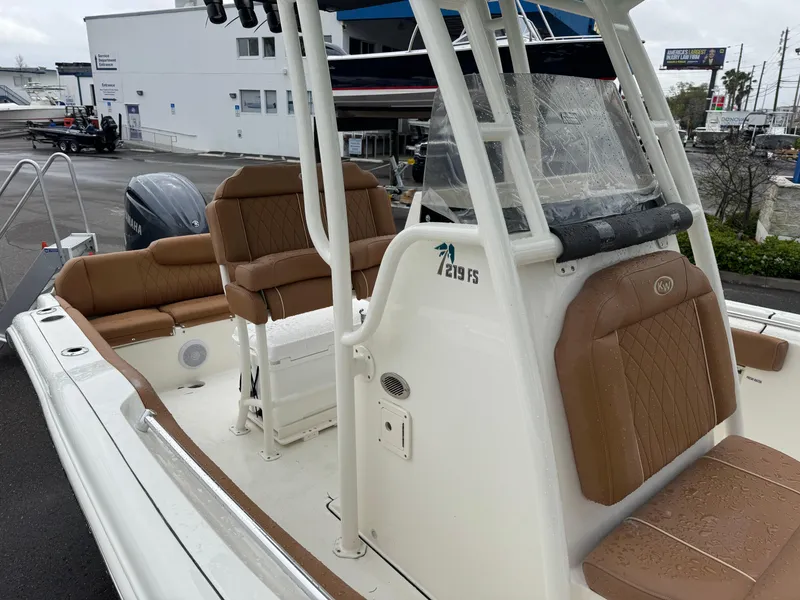 Slide: The Image of 2025 Key West 219 FS boat with tan seating and white exterior, docked at a marina. - 24