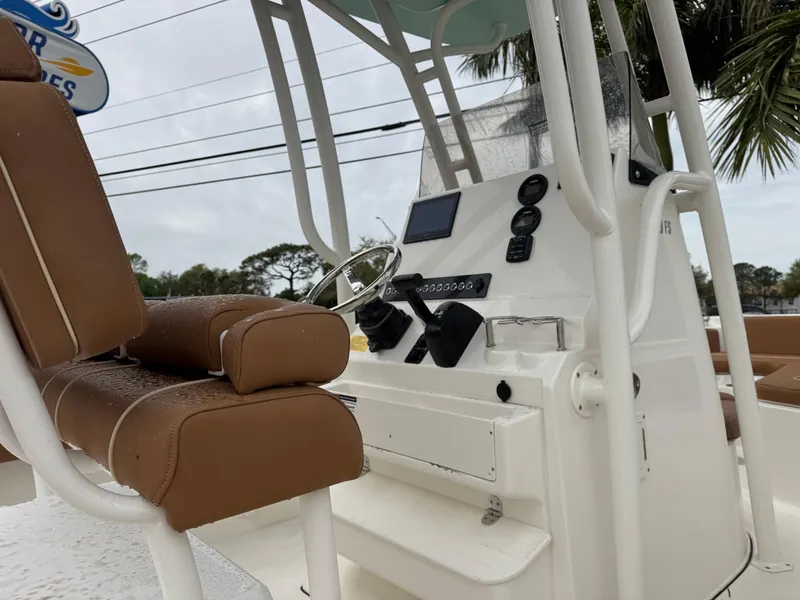 Slide: The Image of 2025 Key West 219 FS boat interior with brown seating and modern control panel. - 25