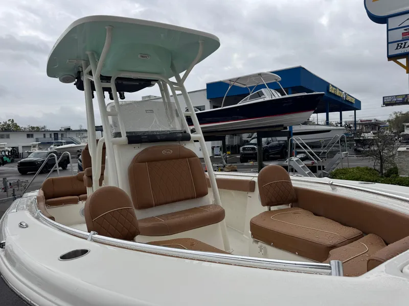 Slide: The Image of 2025 Key West 219 FS boat with tan seating, displayed outdoors at a dealership. - 4