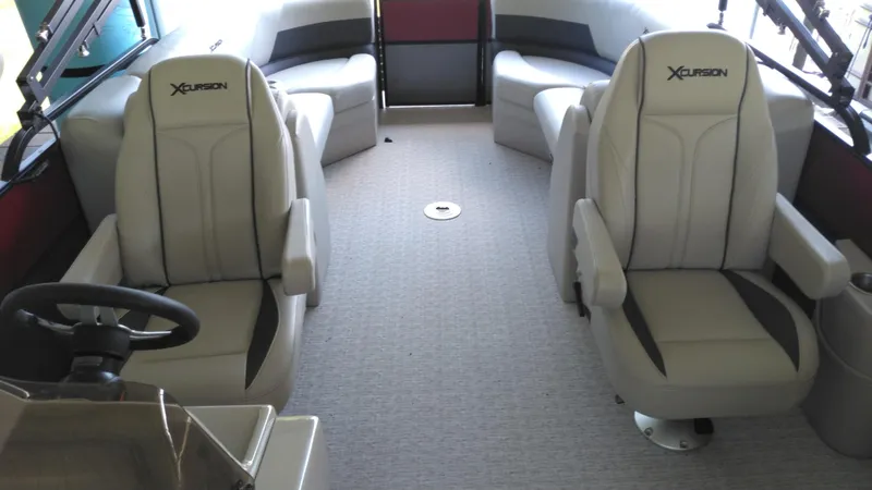 Slide: The Image of 2022 Xcursion 243RFX boat interior with plush seating and steering wheel. - 10