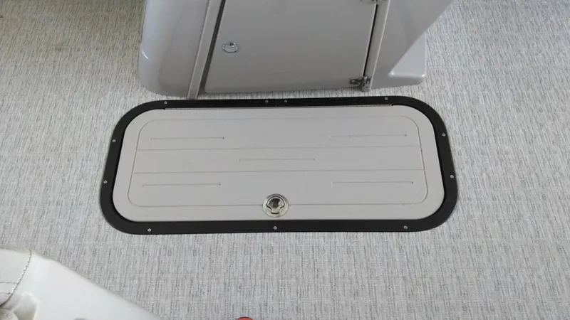 Slide: The Image of 2022 Xcursion 243RFX boat floor hatch with textured surface and secure latch. - 11