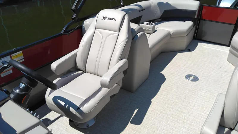 Slide: The Image of 2022 Xcursion 243RFX boat interior with beige seating and steering wheel. - 4