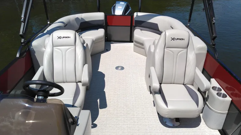 Slide: The Image of 2022 Xcursion 243RFX boat interior with plush seating and steering console. - 5