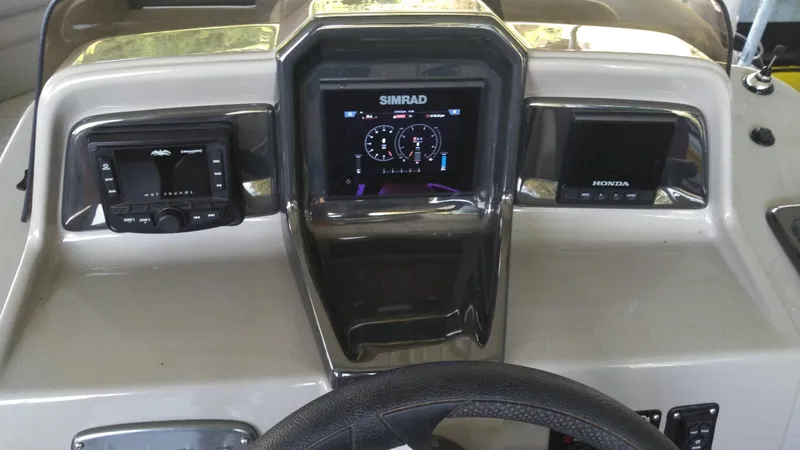 Slide: The Image of 2022 Xcursion 243RFX boat dashboard with Simrad display and controls. - 7