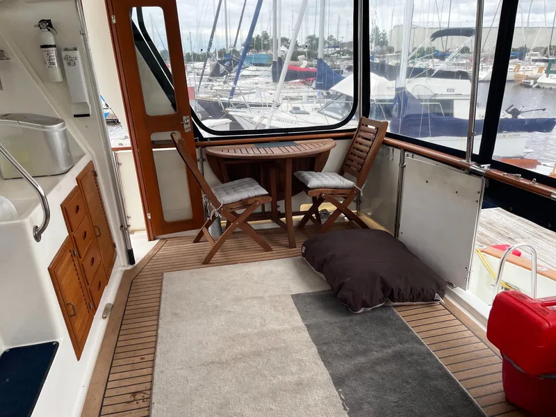 Slide: The Image of 1989 Marine Trader 47 CMY yacht interior with wooden furniture and marina view. - 10