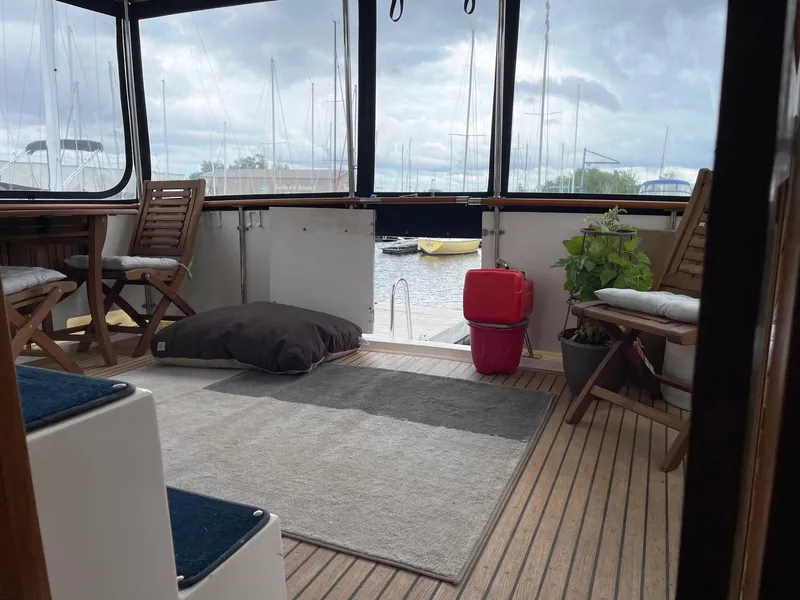 Slide: The Image of 1989 Marine Trader 47 CMY yacht interior with wooden deck, chairs, and marina view. - 11